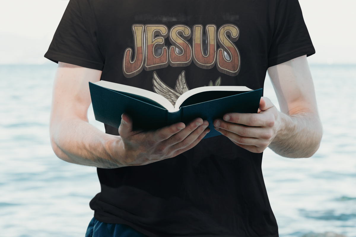 Jesus is King Christian streetwear graphic t-shirt worn by cropped man reading christian passage