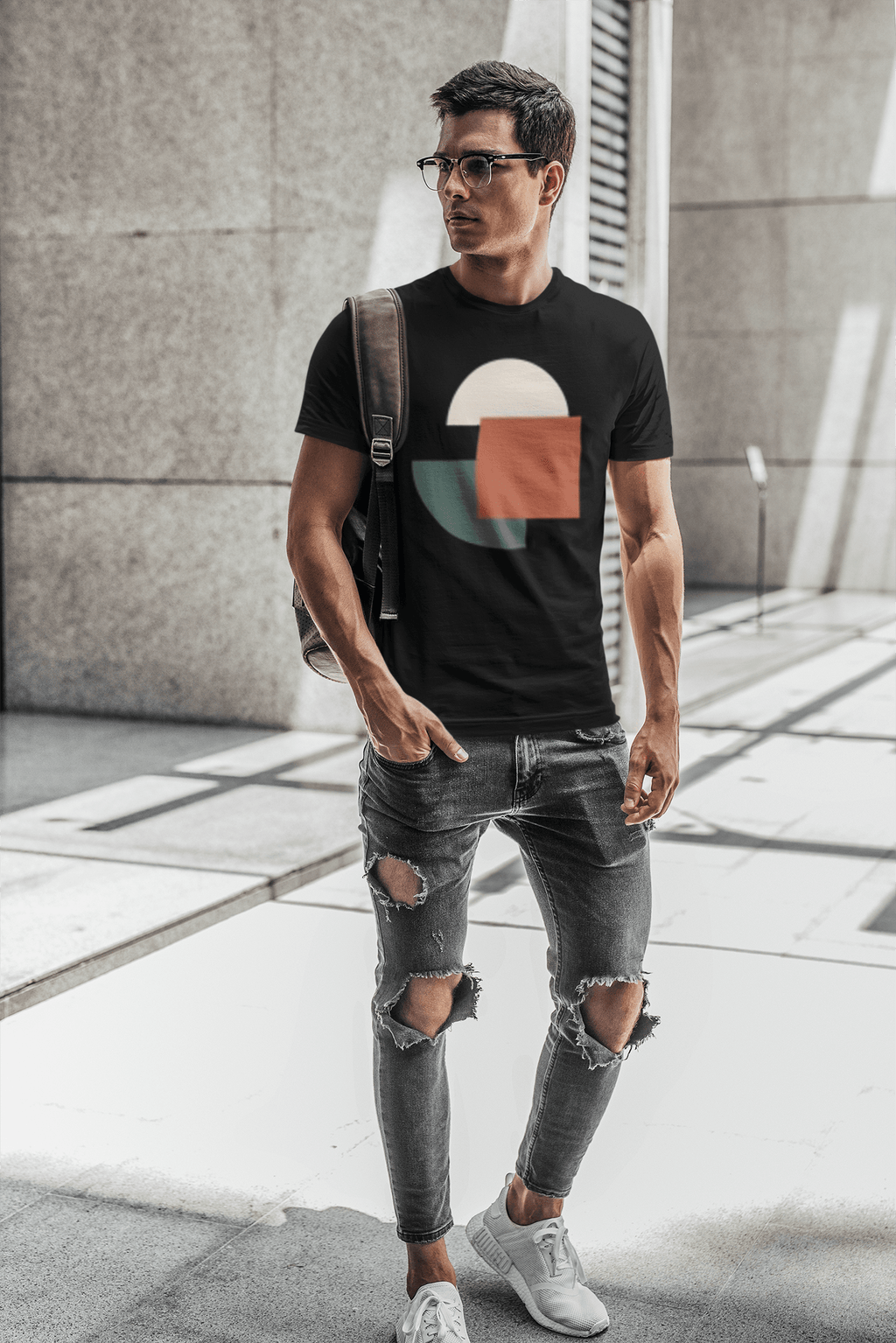 Geometric graphic t-shirt worn by man glasses carrying backpack shoulder