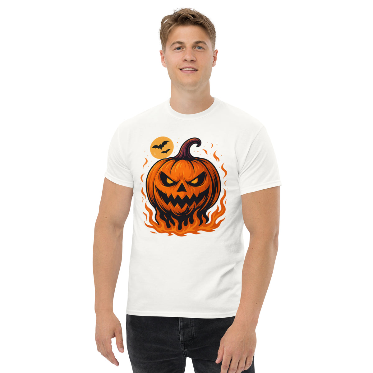 A man wearing a white crewneck t-shirt with a graphic of a glowing jack-o'-lantern pumpkin surrounded by orange flames and a small moon, set against a plain white background.